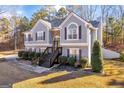 Two-story house with gray siding, dark stairs, and landscaping at 85 Pecan Ln, Oxford, GA 30054