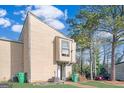 Tan two-story townhouse with green lawn and mature trees at 6036 Regent Mnr, Lithonia, GA 30058