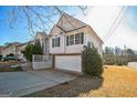 Tan two-story house with a white garage door and landscaping at 221 Stagecoach Pass, Temple, GA 30179