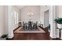 Elegant dining room featuring stylish chandelier lighting, beautiful dark hardwood flooring, and a decorative area rug at 244 Sturry Dr, Mcdonough, GA 30252