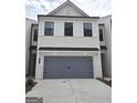 Stylish two-story home features a brick and siding exterior, a gray garage door and a paved driveway at 1946 Westwind Street # 132, Lawrenceville, GA 30043