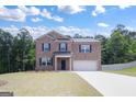 Brick two-story house with attached garage, driveway and landscaping at 4075 Spencer Trail, Stonecrest, GA 30038