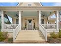 Inviting front porch features a light blue ceiling, ceiling fans, and comfortable seating at 11190 Serenbe Ln, Chattahoochee Hills, GA 30268