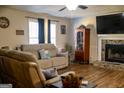 Living room with stone fireplace, TV, tan sofa and decor at 106 Gwenellen Dr, Locust Grove, GA 30248
