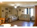 Spacious living room featuring comfortable sofas, ceiling fan and wood-look flooring at 106 Gwenellen Dr, Locust Grove, GA 30248