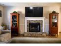 Cozy living room with stone fireplace, wooden curio cabinets, and mounted TV at 106 Gwenellen Dr, Locust Grove, GA 30248