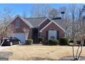 Inviting brick home with a two-car garage, tidy landscaping, and a well-maintained front yard at 213 Meridian Dr, Stockbridge, GA 30281