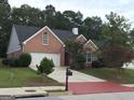 Beautiful red brick home featuring a well-maintained lawn, mature trees, and a cozy residential setting at 213 Meridian Dr, Stockbridge, GA 30281
