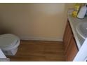 Half bathroom with a wood-look floor, toilet, and small vanity with sink at 2590 Wellington Walk Pl, Lithonia, GA 30058
