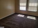 Bright bedroom featuring two sunny windows, plush carpeting and warm, neutral paint at 2590 Wellington Walk Pl, Lithonia, GA 30058