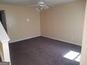 Spacious living room with neutral walls and plush carpeting, illuminated by a modern ceiling fan at 2590 Wellington Walk Pl, Lithonia, GA 30058