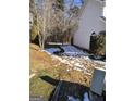 Side yard with patchy grass and light snow cover at 2590 Wellington Walk Pl, Lithonia, GA 30058