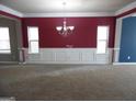 Formal dining room with red walls, wainscoting, and a chandelier at 1340 Napa Valley Dr, Lawrenceville, GA 30045