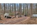 Driveway to house through wooded area with trucks parked at 6051 Reynolds Rd, Morrow, GA 30260