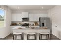 Modern kitchen with white cabinets, granite countertops, stainless steel appliances, and an island at 205 Friendship Oak Way, Hampton, GA 30228