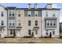 Three-story townhome with gray and white exterior, brick accents, and walkway at 295 Cobalt Dr, Fayetteville, GA 30214