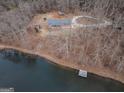 Aerial view of a cozy home with a private lake, surrounded by trees, offering serene waterfront living at 3505 Gum Creek Rd, Oxford, GA 30054