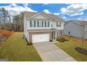 Two-story house with gray siding, brick accents, and a two-car garage at 6817 Chataran Dr, Lithia Springs, GA 30122