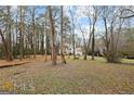 Spacious backyard with mature trees surrounding the house at 5045 Rock Springs Rd, Lithonia, GA 30038