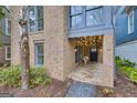 Charming brick exterior with string lights, a stone porch, and beautiful landscaping at 147 Hubbard Rd, Woodstock, GA 30188