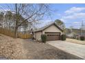 Angle view of the home's exterior, emphasizing the large garage and surrounding yard at 546 Paden Dr, Lawrenceville, GA 30044