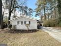 Gray brick house with a carport and mature trees surrounding the property at 2729 Pinella Sw Dr, Atlanta, GA 30331