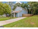 Charming blue home featuring a well-maintained lawn and long driveway at 1302 Ladd St, Atlanta, GA 30310