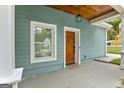 Inviting blue house exterior featuring a light wood front door with a charming lantern fixture at 1302 Ladd St, Atlanta, GA 30310
