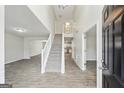 Bright entryway with tile flooring, staircase, and view to kitchen at 9507 Byrom Rd, Jonesboro, GA 30236