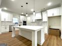 Bright, spacious kitchen features white cabinets, a large island, and stainless steel appliances at 4619 Parkwood Rd, Social Circle, GA 30025