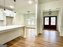 Open-concept kitchen and dining area with modern pendant lighting and hardwood floors at 4619 Parkwood Rd, Social Circle, GA 30025