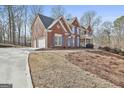 Beautiful two-story brick home with three-car garage and long driveway at 230 Hedgewick Way, Tyrone, GA 30290