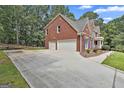 Side view of the home featuring a three-car garage and extra-long driveway at 230 Hedgewick Way, Tyrone, GA 30290