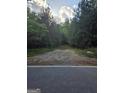 Wooded lot with a dirt road leading into it at 8025 Creekwood Dr, Fairburn, GA 30213