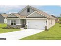 Gray siding, brick accents, two-car garage, and a well-manicured lawn at 1025 Claas Way, Locust Grove, GA 30248