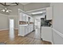 The kitchen features white cabinets, brick backsplash and stainless steel appliances at 110 Cloverwood Dr, Fayetteville, GA 30215