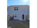 Backyard of a townhome with gray siding, a patio, and a newly seeded lawn under a bright blue sky at 137 Swindon Dr, Mcdonough, GA 30253