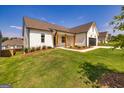 White farmhouse exterior with a large yard and two-car garage at 69 Oakhurst Trl, Sharpsburg, GA 30277