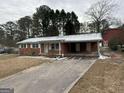 Brick ranch house with attached carport, snow on roof at 6148 Park Dr, Forest Park, GA 30297