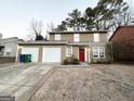 Tan two-story house with a red front door and attached garage at 3880 Springleaf Ct, Stone Mountain, GA 30083
