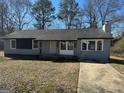 Newly painted gray house with a paved driveway and mature trees at 285 Queen Helen Ln, Jonesboro, GA 30236
