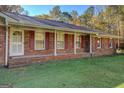 Brick house showcasing a covered porch and well-maintained landscaping at 155 Island Shoals Rd, Covington, GA 30016