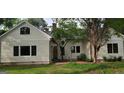 Side exterior of home with brick walkway, a lush garden, and mature landscaping at 213 W Hightower Trl, Social Circle, GA 30025