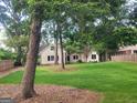 Spacious lawn with mature trees surrounding charming home in a serene setting at 213 W Hightower Trl, Social Circle, GA 30025
