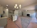 Open-concept living area featuring a cozy fireplace, a decorative light fixture, and seamless flow to the kitchen at 142 Asa Moseley Rd, Mcdonough, GA 30252