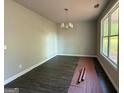 Sunlit, spacious living room showcasing new flooring and a modern lighting fixture for a comfortable atmosphere at 142 Asa Moseley Rd, Mcdonough, GA 30252