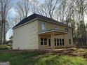 Rear view of a yellow house showing covered patio and expansive green space at 142 Asa Moseley Rd, Mcdonough, GA 30252