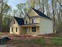 Side view of a yellow home with black roof showing covered porch and large backyard at 142 Asa Moseley Rd, Mcdonough, GA 30252