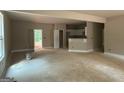 An open-concept living room space featuring view into kitchen area and access to exterior at 150 Asa Moseley Rd, Mcdonough, GA 30252