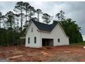 Side view of new home featuring an attached garage and white siding against a green backdrop at 136 Asa Moseley Rd, Mcdonough, GA 30252
